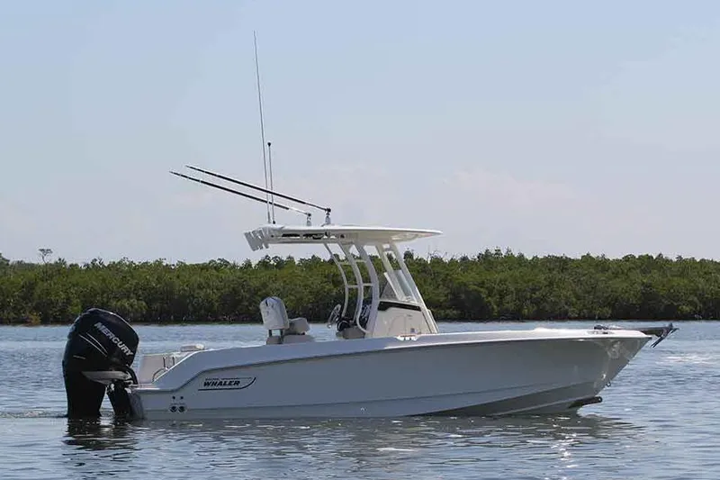 Slide: The Image of Manufacturer Provided Image: 2018 Boston Whaler 230 Outrage boat on calm water with lush greenery in the background. - 17