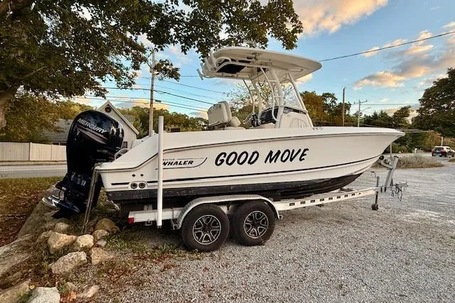Slide: The Image of 2018 Boston Whaler 230 Outrage boat on trailer, labeled "Good Move," parked outdoors. - 2