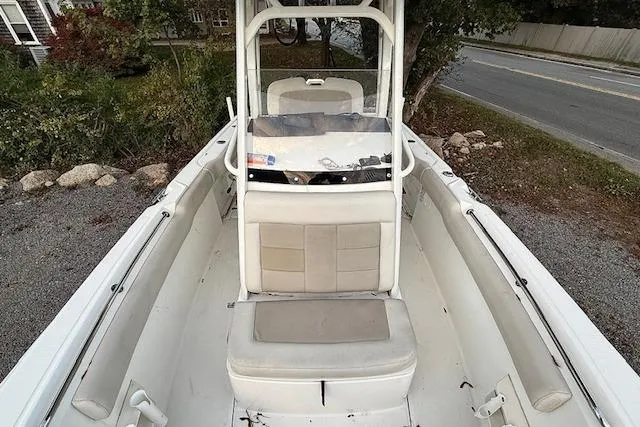 Slide: The Image of 2018 Boston Whaler 230 Outrage boat interior with seating and console, parked on gravel. - 6
