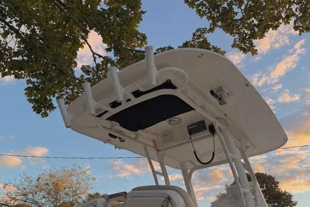 Slide: The Image of 2018 Boston Whaler 230 Outrage boat under a tree with a blue sky background. - 7