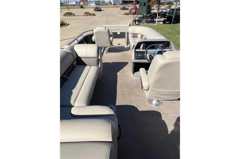 Slide: The Image of 2024 Sun Tracker SportFish 20 DLX pontoon boat interior with beige seating and steering console. - 4