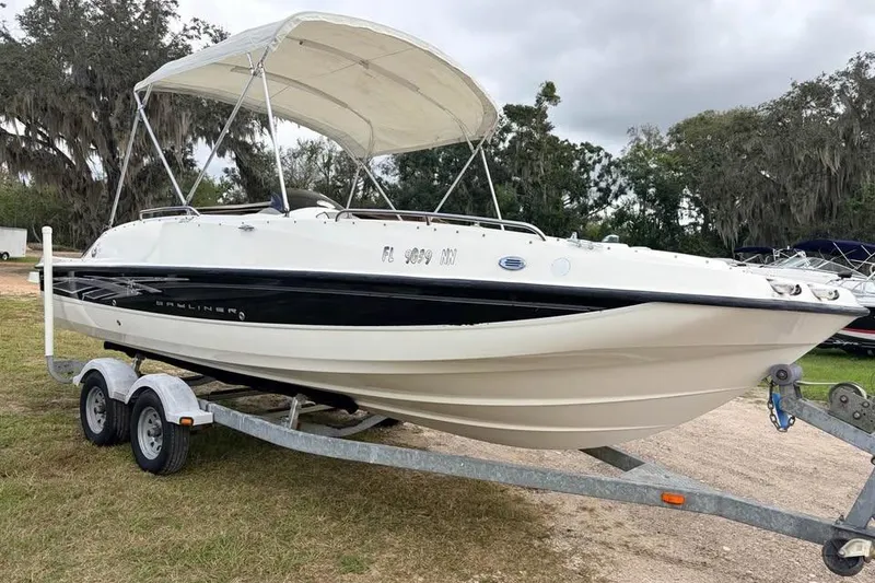 Slide: The Image of 2007 Bayliner 217 Deck Boat on trailer with canopy, parked outdoors. - 3