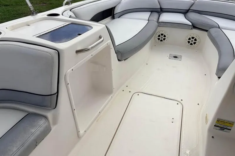 Slide: The Image of 2007 Bayliner 217 Deck Boat interior with cushioned seating and storage compartments. - 9