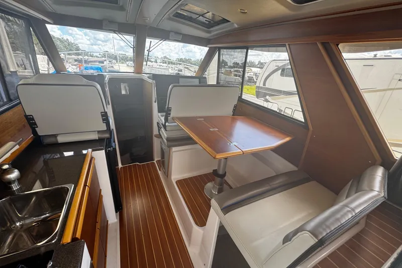 Slide: The Image of 2019 Cutwater C-28 interior with dining area, kitchenette, and wood accents. - 3