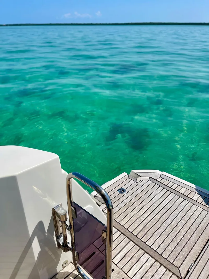 Slide: The Image of Beneteau Swift Trawler 41 Fly 2021, swim platform overlooking clear turquoise water. - 19