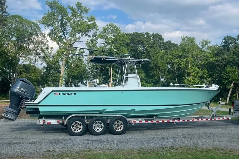 The Image of 2011 Contender 32 ST boat on trailer, parked outdoors with trees in background. - 1