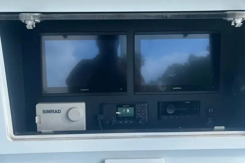 Slide: The Image of 2011 Contender 32 ST dashboard with Garmin and Simrad navigation displays. - 10