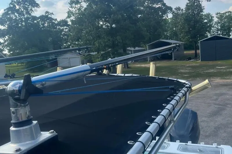 Slide: The Image of 2011 Contender 32 ST boat with fishing rods on deck, surrounded by trees and sheds. - 11