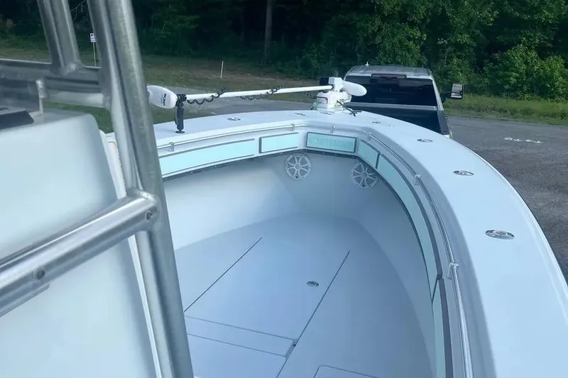 Slide: The Image of 2011 Contender 32 ST boat with trolling motor, parked near a forested area. - 6