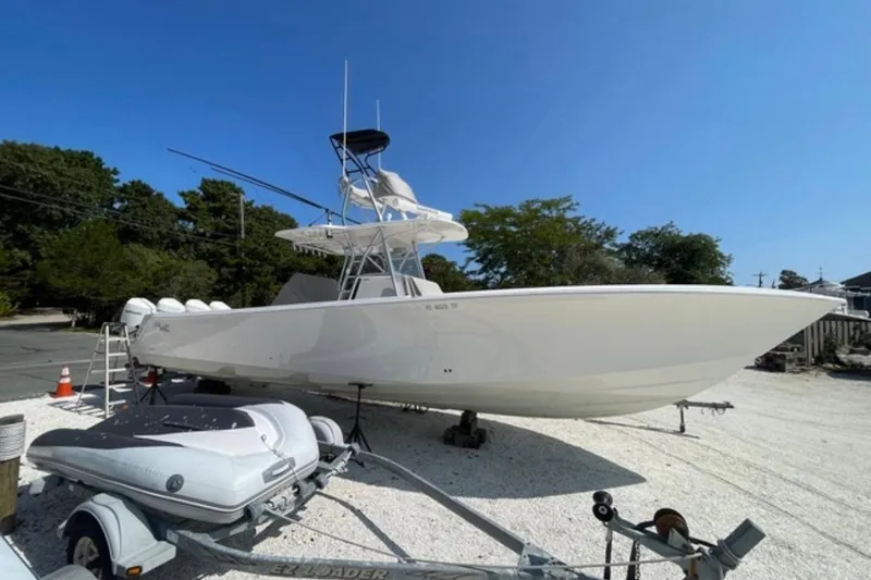 The Image of 2023 SeaVee 390Z boat on trailer, parked outdoors under clear blue sky. - 0