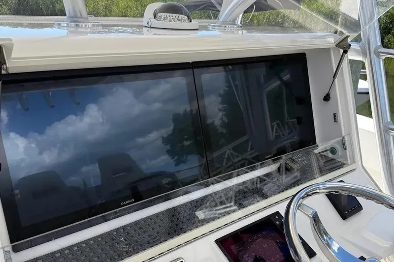 Slide: The Image of 2023 SeaVee 390Z boat dashboard with Garmin displays and steering wheel. - 5