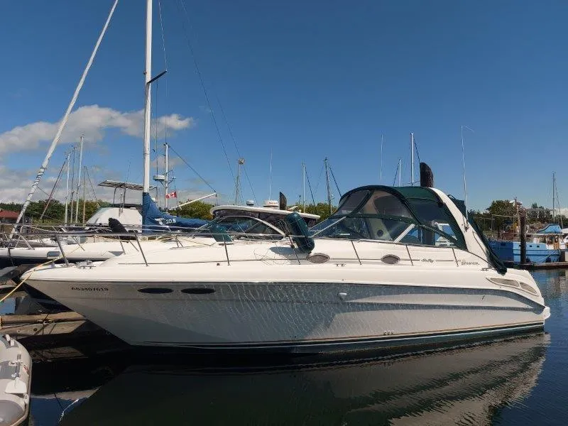 The Image of 1999 Sea Ray 340 Sundancer yacht docked in a marina under clear blue skies. - 0