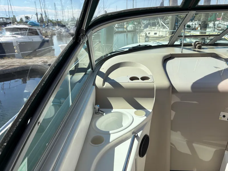 Slide: The Image of 1999 Sea Ray 340 Sundancer cockpit with sink, cup holders, and marina view. - 10