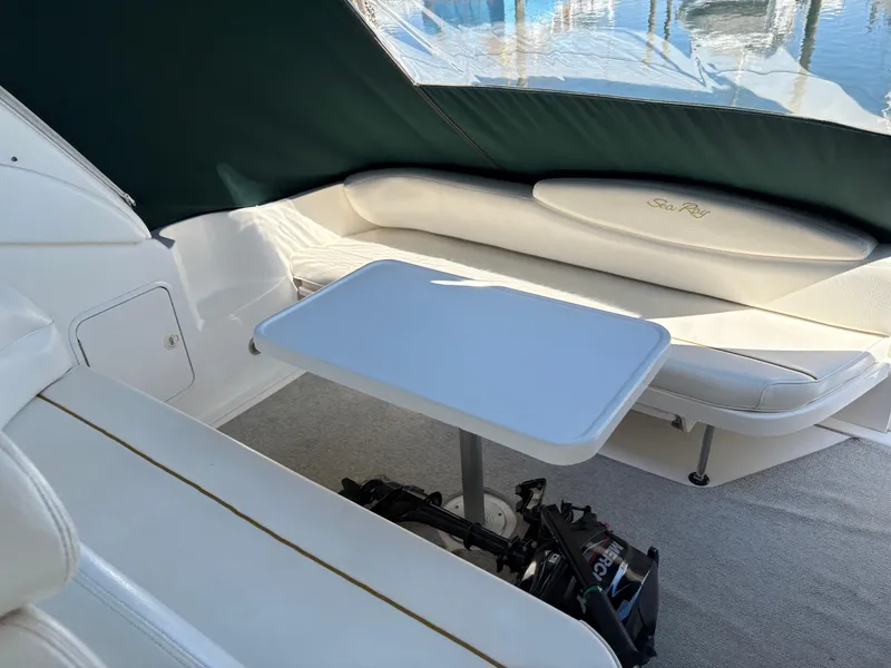 Slide: The Image of 1999 Sea Ray 340 Sundancer interior with seating and table, under green canopy. - 11