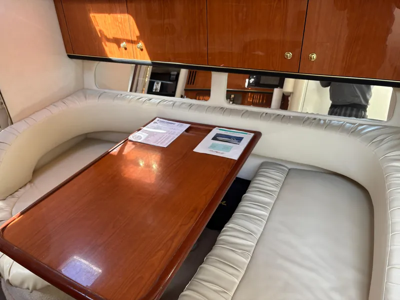 Slide: The Image of Interior of 1999 Sea Ray 340 Sundancer with wooden table and cushioned seating. - 22