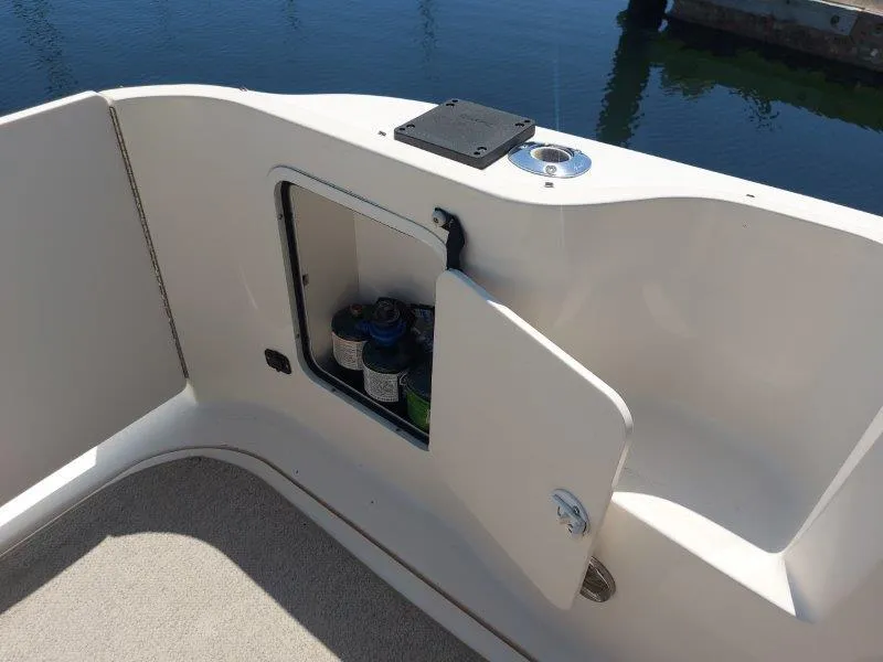 Slide: The Image of 1999 Sea Ray 340 Sundancer storage compartment with open door, revealing interior contents. - 39