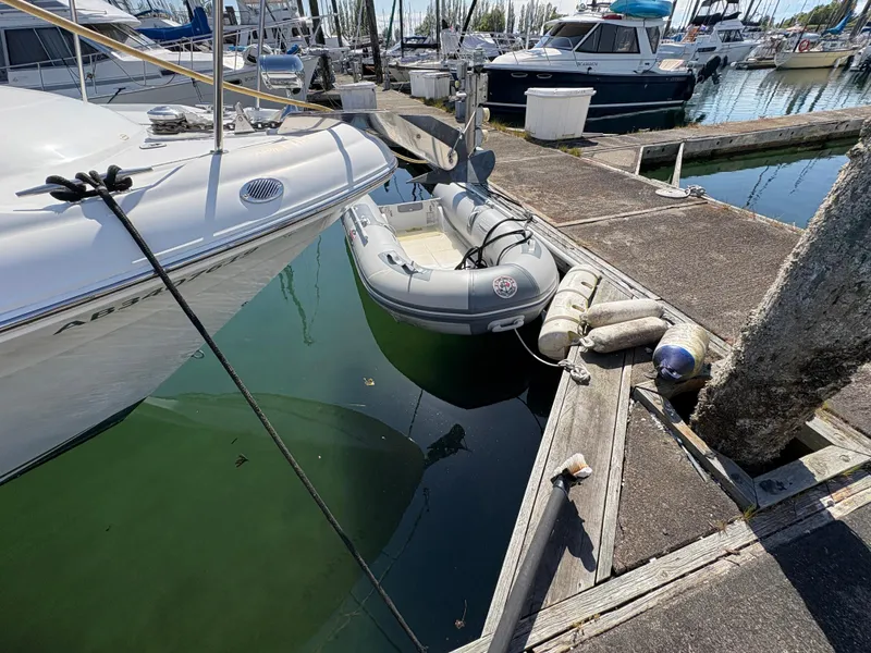 Slide: The Image of 1999 Sea Ray 340 Sundancer docked with inflatable boat, marina setting. - 4