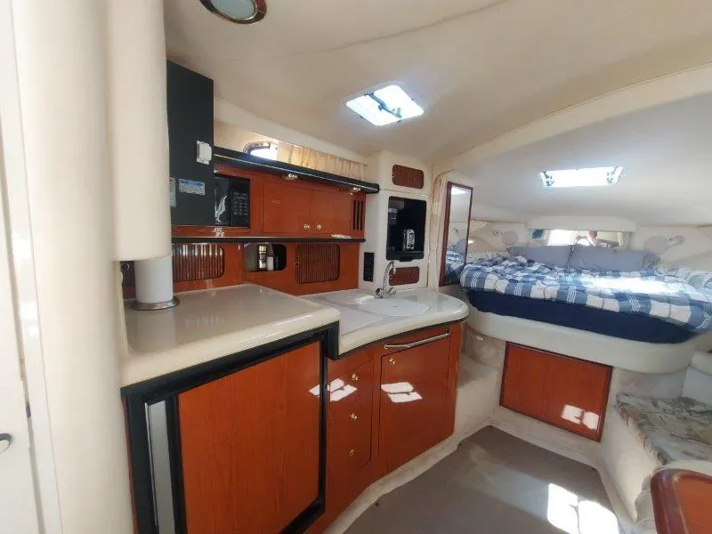 Slide: The Image of Interior of 1999 Sea Ray 340 Sundancer with kitchenette and cozy sleeping area. - 44