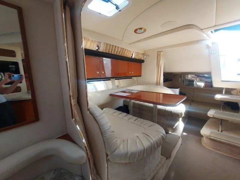 Slide: The Image of Interior of 1999 Sea Ray 340 Sundancer yacht with plush seating and wooden table. - 45