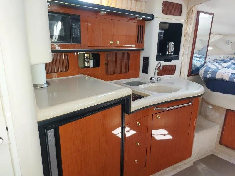 Slide: The Image of Interior of 1999 Sea Ray 340 Sundancer yacht with kitchenette and sleeping area. - 49
