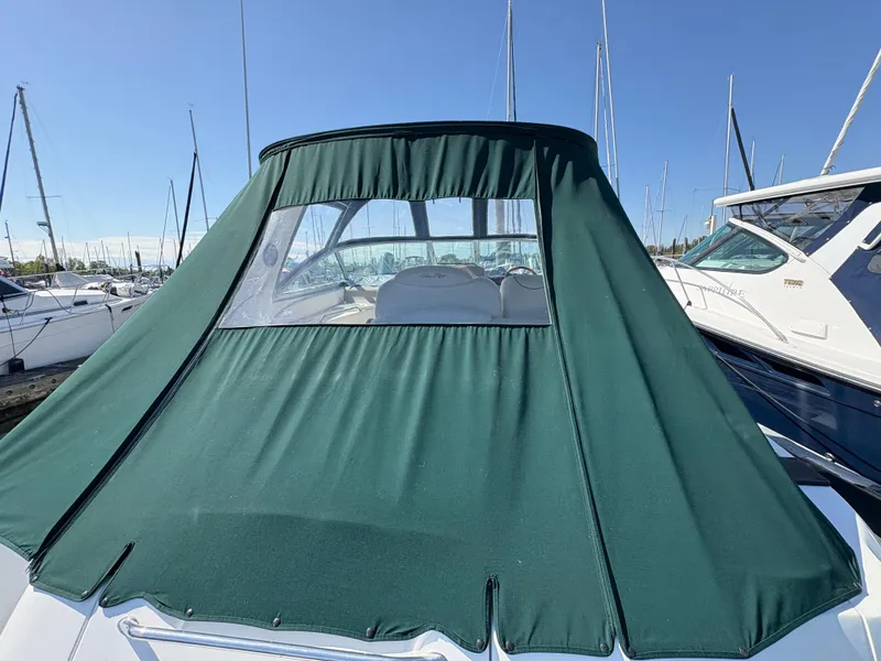 Slide: The Image of 1999 Sea Ray 340 Sundancer with green canvas cover in marina setting. - 7