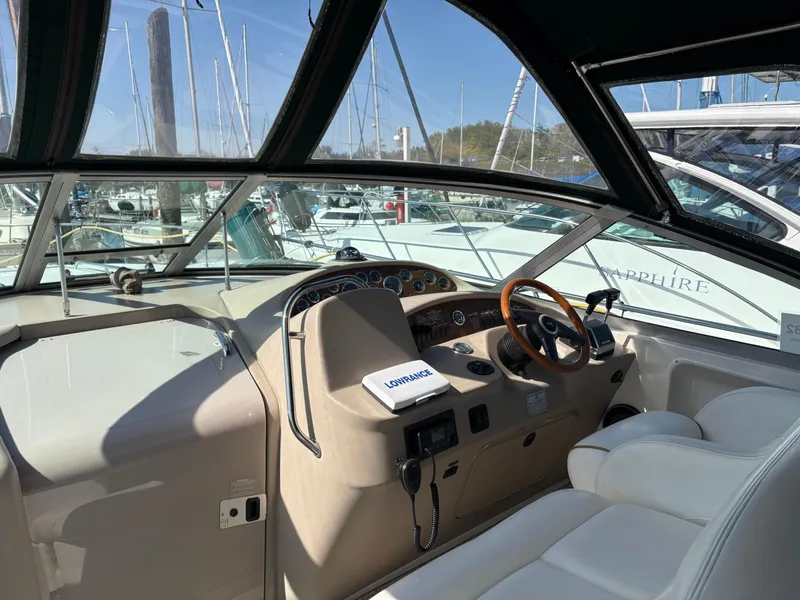 Slide: The Image of 1999 Sea Ray 340 Sundancer cockpit with steering wheel, dashboard, and marina view. - 8