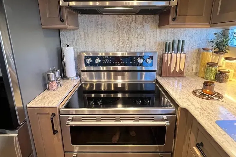 Slide: The Image of Modern kitchen with stainless steel oven, knife set, and decorative jars on marble countertops. - 18