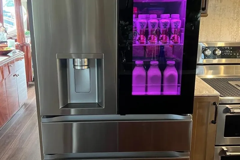 Slide: The Image of Modern stainless steel refrigerator with purple-lit beverage display on a 2004 Lazzara SC Motor Yacht. - 26