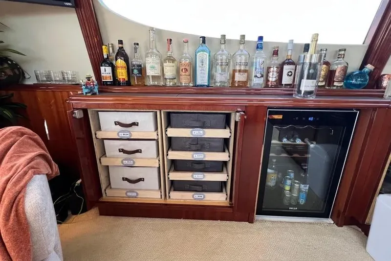 Slide: The Image of Luxurious bar setup on a 2004 Lazzara SC Motor Yacht with liquor bottles and mini fridge. - 53