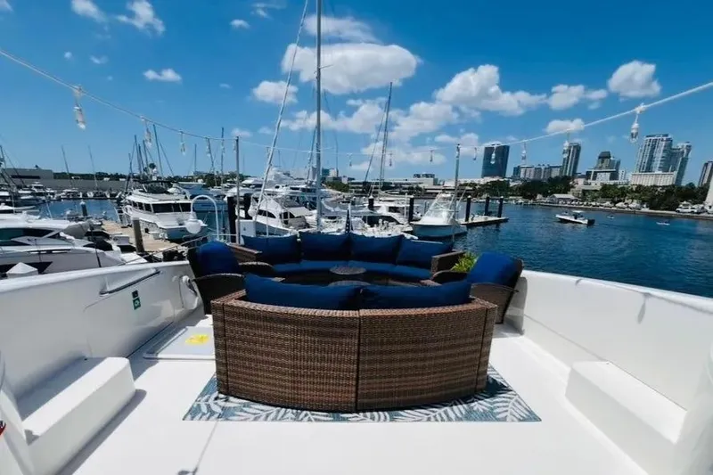 Slide: The Image of 2004 Lazzara SC Motor Yacht deck with blue seating, overlooking marina and city skyline. - 57