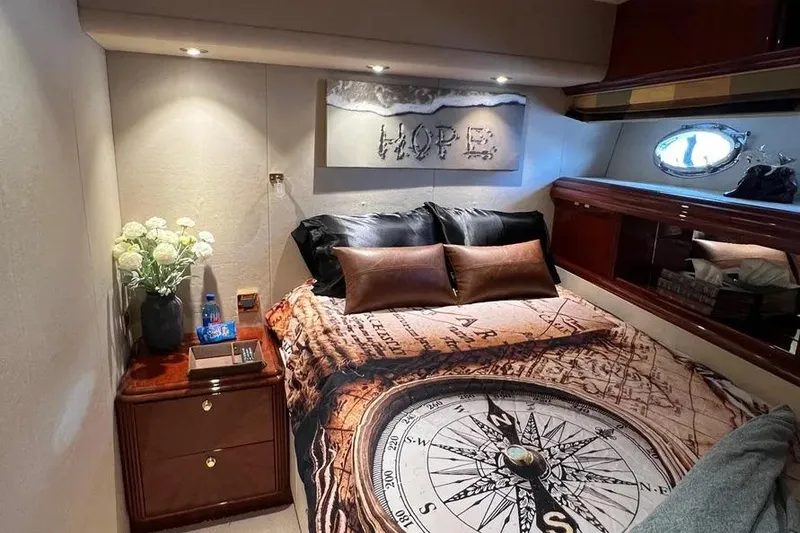 Slide: The Image of Luxurious 2004 Lazzara SC Motor Yacht bedroom with compass-themed bedding and elegant decor. - 62