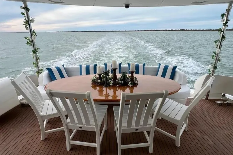 Slide: The Image of 2004 Lazzara SC Motor Yacht deck with elegant dining setup and ocean view. - 7