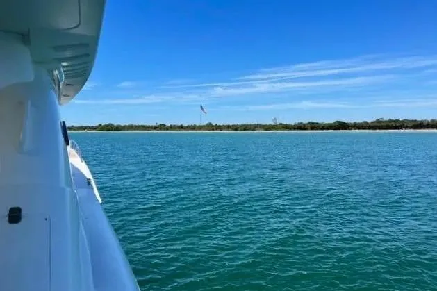 Slide: The Image of 2004 Lazzara SC Motor Yacht cruising on serene blue waters under clear skies. - 9