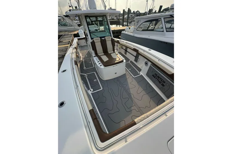 Slide: The Image of 2024 Caymas 34 CT boat interior with sleek seating and modern design at a marina. - 11