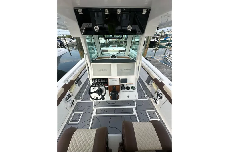 Slide: The Image of 2024 Caymas 34 CT boat cockpit with Garmin navigation, luxurious seating, and modern controls. - 13