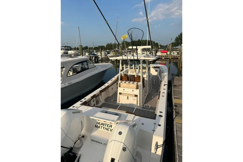 Slide: The Image of 2024 Caymas 34 CT boat docked at marina, featuring fishing equipment and spacious deck. - 16