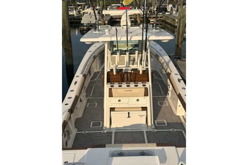 Slide: The Image of 2024 Caymas 34 CT boat with fishing rods, docked at a marina. - 18