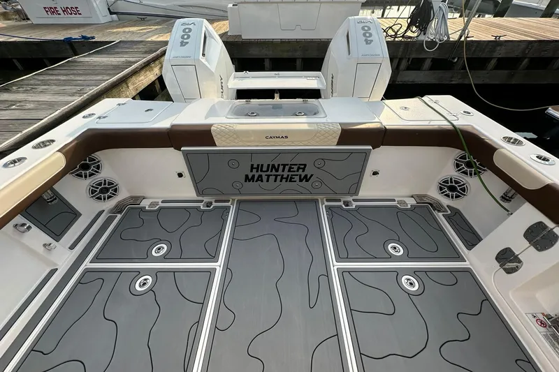 Slide: The Image of 2024 Caymas 34 CT boat deck with custom flooring and twin outboard engines. - 20