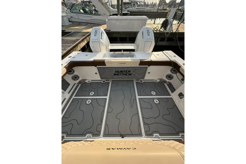 Slide: The Image of 2024 Caymas 34 CT boat deck with custom flooring and seating at a marina. - 21