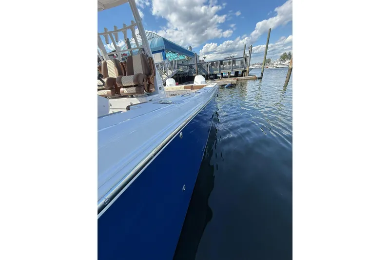 Slide: The Image of 2024 Caymas 34 CT boat docked, featuring sleek blue hull and comfortable seating. - 3