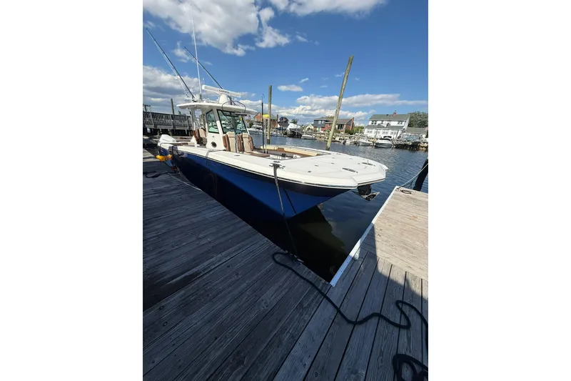 Slide: The Image of 2024 Caymas 34 CT boat docked, featuring sleek design and spacious deck under a clear sky. - 4