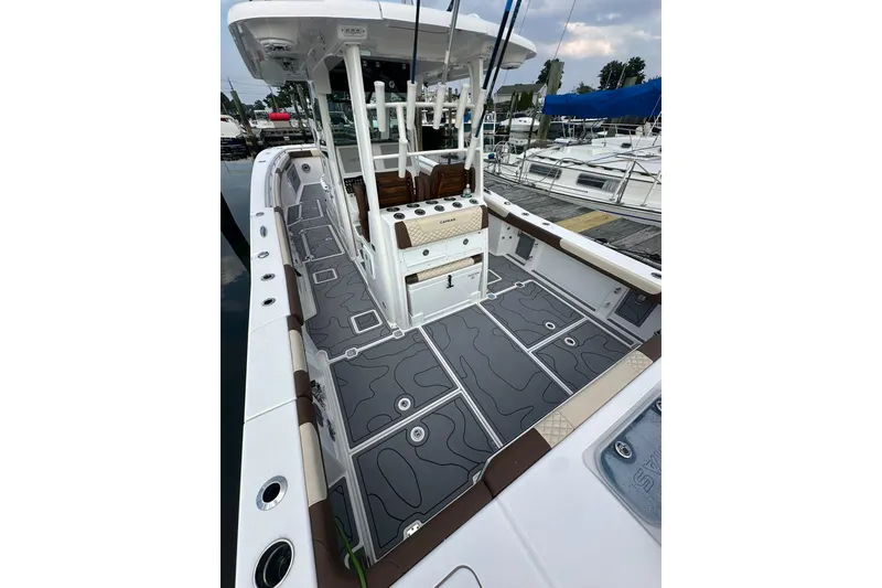 Slide: The Image of 2024 Caymas 34 CT boat with sleek deck design at a marina. - 8