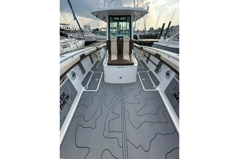 Slide: The Image of 2024 Caymas 34 CT boat interior with sleek seating and modern design at a marina. - 9