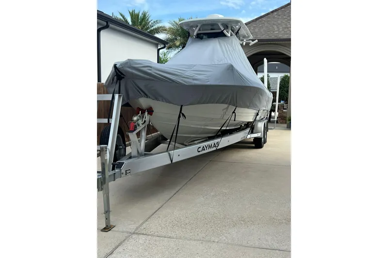Slide: The Image of 2024 Caymas 281 HB boat covered on trailer in driveway. - 14