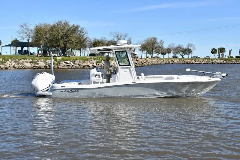 Slide: The Image of 2024 Caymas 281 HB boat cruising on a calm river with trees in the background. - 2