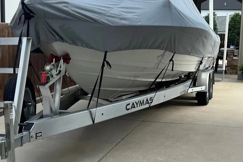 Slide: The Image of 2024 Caymas 281 HB boat covered on a trailer in a driveway. - 4