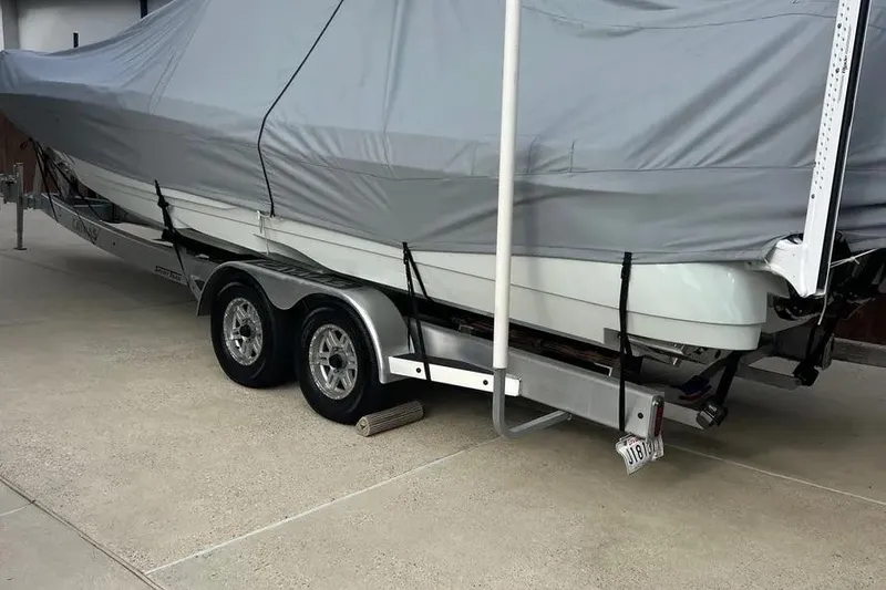 Slide: The Image of 2024 Caymas 281 HB boat covered on a trailer in a driveway. - 5