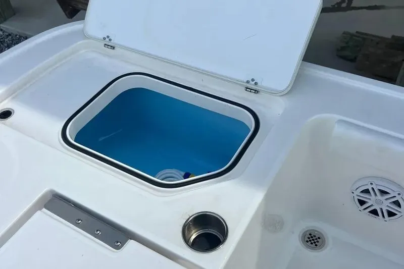 Slide: The Image of 2024 Caymas 281 HB boat with open storage compartment and cup holder. - 8
