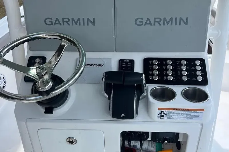 Slide: The Image of 2024 Caymas 281 HB boat console with Garmin displays and Mercury controls. - 9