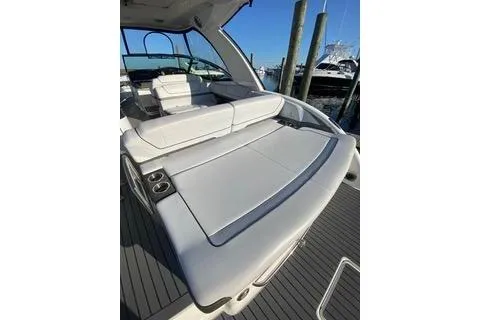 Slide: The Image of 2018 Formula 350 Crossover Bowrider with spacious seating and sleek design at a marina. - 7